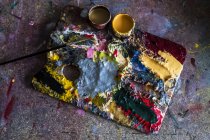 High angle close-up of palette, oil paints and paintbrush in workshop. — Stock Photo