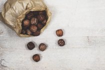 High angle close-up of brown paper bag with fresh walnuts. — Stock Photo