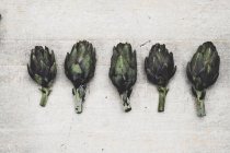 Primer plano de alcachofas frescas sobre fondo gris . - foto de stock