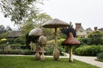 Hohe aus Holz geschnitzte Fliegenpilze Gartenskulpturen in Oxfordshire, England — Stockfoto