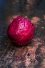 Shiny fresh raw red cabbage on worn tabletop. — Stock Photo