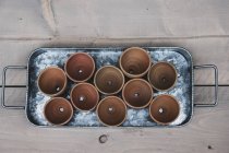 Primo piano ad angolo alto di vasi di terracotta su vassoio di metallo . — Foto stock