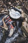 High angle close-up of metal kettle hanging over campfire. — Stock Photo