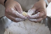 Nahaufnahme einer Person, die Butter und Mehl einreibt, um zwischen den Fingern zu zerbröseln. — Stockfoto