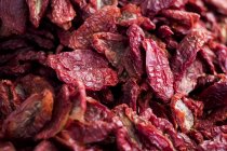 Close-up of dried red tomatoes at food market stall. — Stock Photo