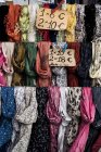 Primo piano di una vasta selezione di sciarpe colorate al banco del mercato . — Foto stock