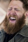 Retrato de hombre barbudo riendo con cabello castaño . - foto de stock