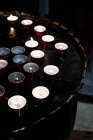Großaufnahme brennender Teelichterkerzen auf Tablett in der Kirche. — Stockfoto