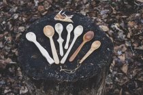 High angle close-up of selection of carved wooden spoons on chopping block. — Stock Photo