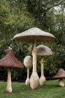 Hohe aus Holz geschnitzte Fliegenpilze Gartenskulpturen in Oxfordshire, England — Stockfoto