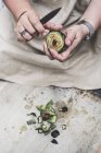 Close-up de pessoa descascando alcachofra fresca com faca de cozinha . — Fotografia de Stock