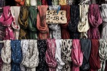 Primer plano de gran selección de bufandas de colores en el puesto de mercado . - foto de stock