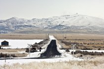 Cruzamento ferroviário coberto de neve com montanhas em Utah, EUA — Fotografia de Stock