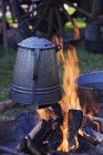Coffee pot over open fire with logs, close-up — Stock Photo