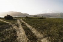 Yourts et chemin de terre au soleil doux, Lac Karakul, Kirghizistan — Photo de stock