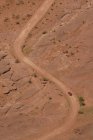 Vista aérea de SUV na estrada de terra em paisagem rochosa — Fotografia de Stock
