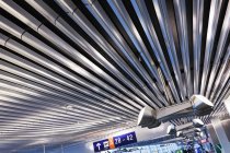 Lighting and signs on corrugated style ceiling in airport — Stock Photo