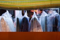 Dry-cleaned clothing in plastic bags hanging in laundry, Seattle, Washington, United States — Stock Photo