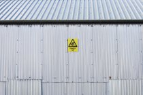 Señal de advertencia en antiguo edificio industrial - foto de stock