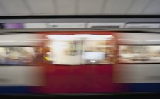 Поезд метро в движении размыл рельсы в Лондоне, Англия, Великобритания — стоковое фото