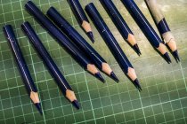 Hochwinkel-Nahaufnahme gespitzter blauer Bleistifte auf grüner Schnittmatte. — Stockfoto