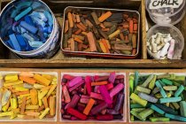 High angle close-up of wooden box with crayons in variety of vibrant colors. — Stock Photo