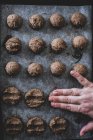 Высокий угол крупным планом человека руки положить шоколадное печенье тесто на поднос для выпечки . — стоковое фото