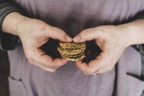 Close-up of person holding small stack of freshly baked seeded crackers. — Stock Photo