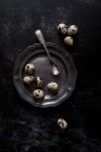 Олов'яні пластини з невеликими плямистих перепелині яйця і урожай ложка, вид зверху. — стокове фото