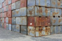 Стопки ржавых металлических контейнеров с номерами на погрузочной платформе . — стоковое фото
