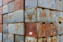 Stacks of rusty metal containers with numbers at loading dock. — Stock Photo