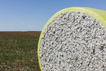 Empacadura de algodón cosechada envuelta en vinilo plástico amarillo en Great Plains, Kansas, EE.UU. - foto de stock