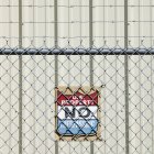 Warning sign and metal chain link fence — Stock Photo