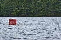Panneau d'avertissement rouge ornithologique dans l'eau du lac — Photo de stock