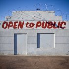 Closed business with advertisement in desert with barbed wire — Stock Photo