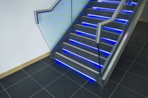 Modern office staircase with blue neon illumination — Stock Photo