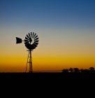 Mulino a vento in silhouette contro arancio cielo tramonto — Foto stock
