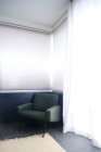 Cadeira em sala de cor clara com tapete e cortina — Fotografia de Stock