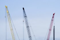 Colorful tower cranes against blue sky — Stock Photo