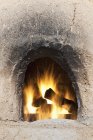 Adobe oven with logs and fire, Taos, Nuevo México, Estados Unidos - foto de stock