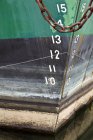 Casco de barco con cadena oxidada y números, primer plano - foto de stock