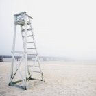 Empty lifeguard station and wooden pier in fog, Panama City Beach, Florida, USA — Stock Photo