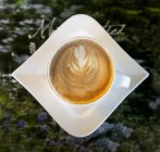 Latte coffee with leaf design in modern cafe in Tartu, Estonia — Stock Photo