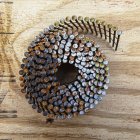 Coiled framing nails in wooden board surface, close-up — Stock Photo