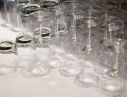 Primer plano de vasos limpios al revés en la mesa - foto de stock