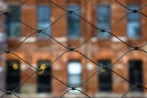 Міські дротяні сітки паркан з будівлею в селективний фокус, Нью-Йорк, Нью-Йорк, США — стокове фото