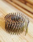 Coiled framing nails in wooden board surface, close-up — Stock Photo