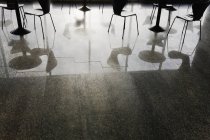 Reflexão de mesas e cadeiras no chão brilhante do restaurante — Fotografia de Stock