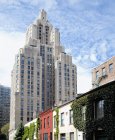 Хмарочос підноситься над багатоквартирних будинків, Нью-Йорк, Нью-Йорк, Сполучені Штати — стокове фото