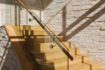 Висококласні дерев'яні сходи в будинку на сонячному світлі — стокове фото